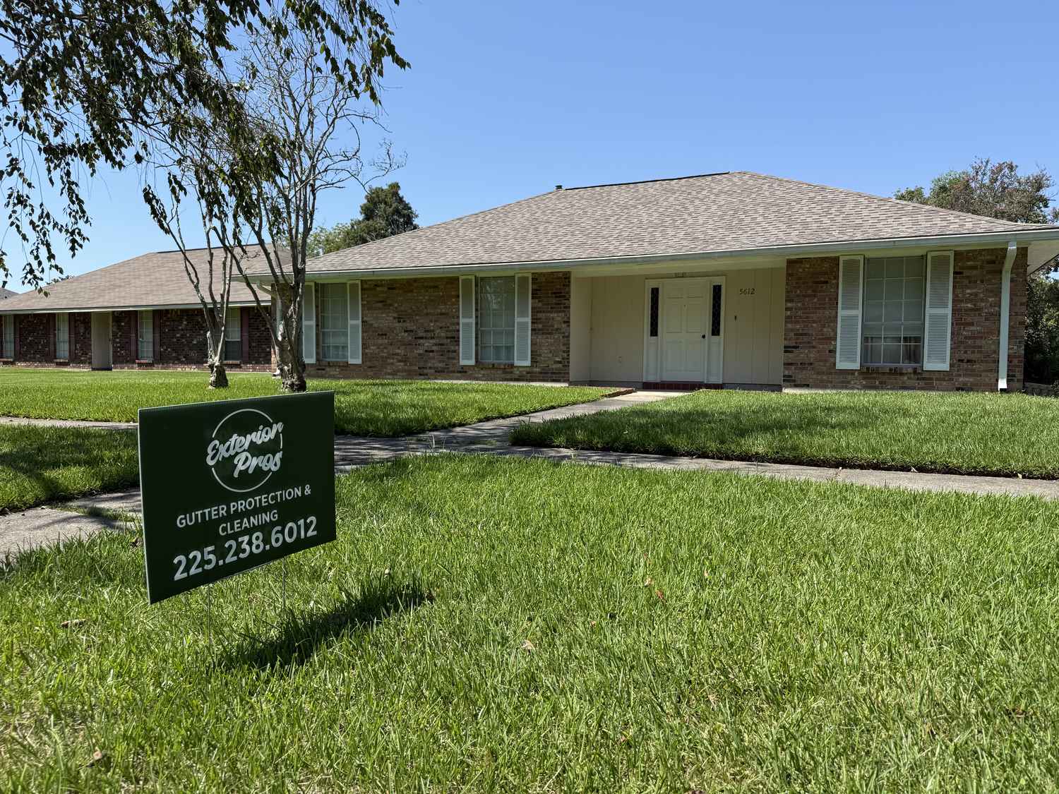Exterior Pros yard sign in front of a completed gutter job in Ascension Parish