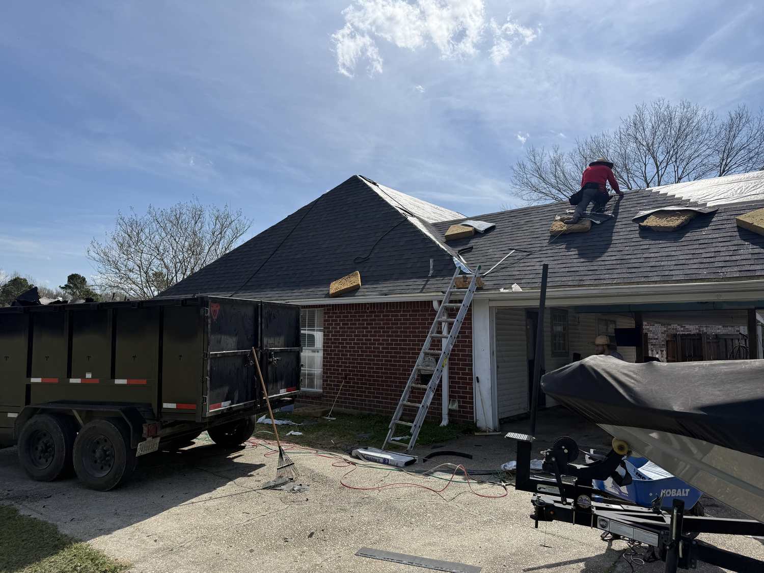 Roof replacement in progress during tear-off, showing an aged shingle roof coming off a Louisiana home