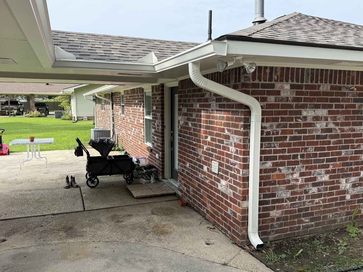 New seamless gutters installed along a brick carport roofline in Louisiana